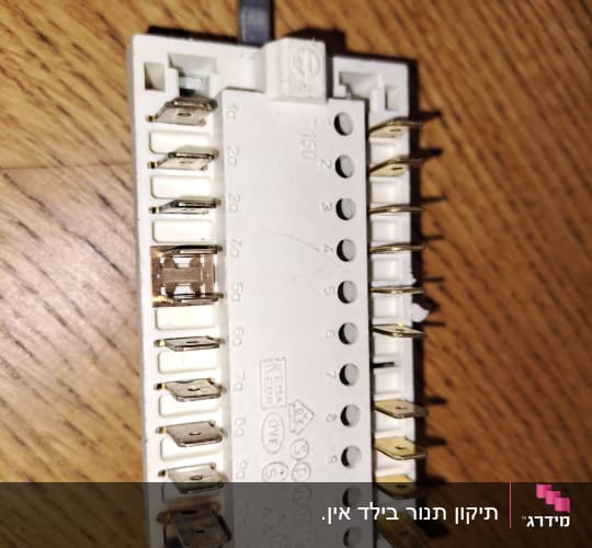 מתג חשמלי עם חיבורים מתכתיים על רקע עץ